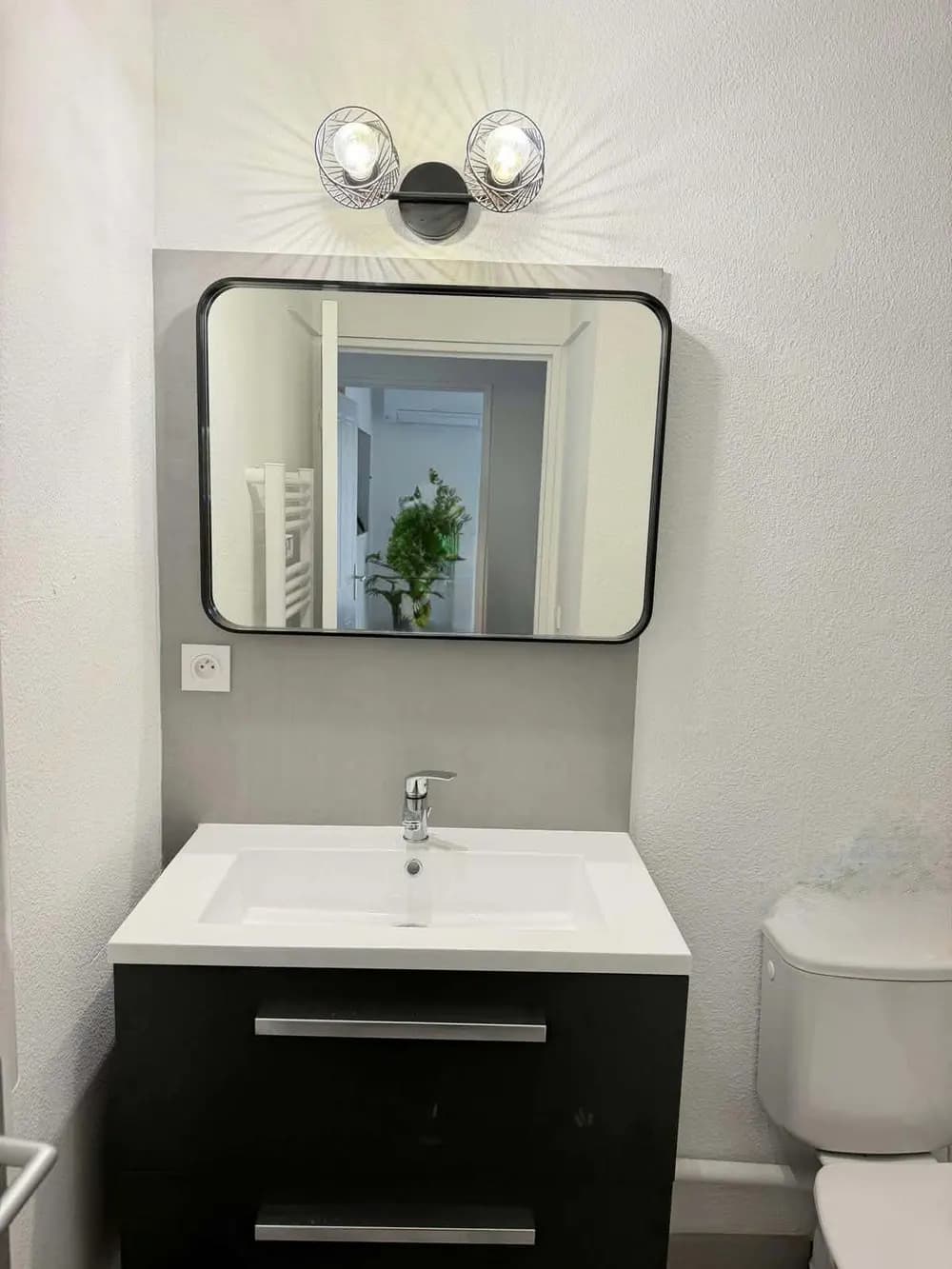 Nouveau meuble vasque devant un panneau mural gris